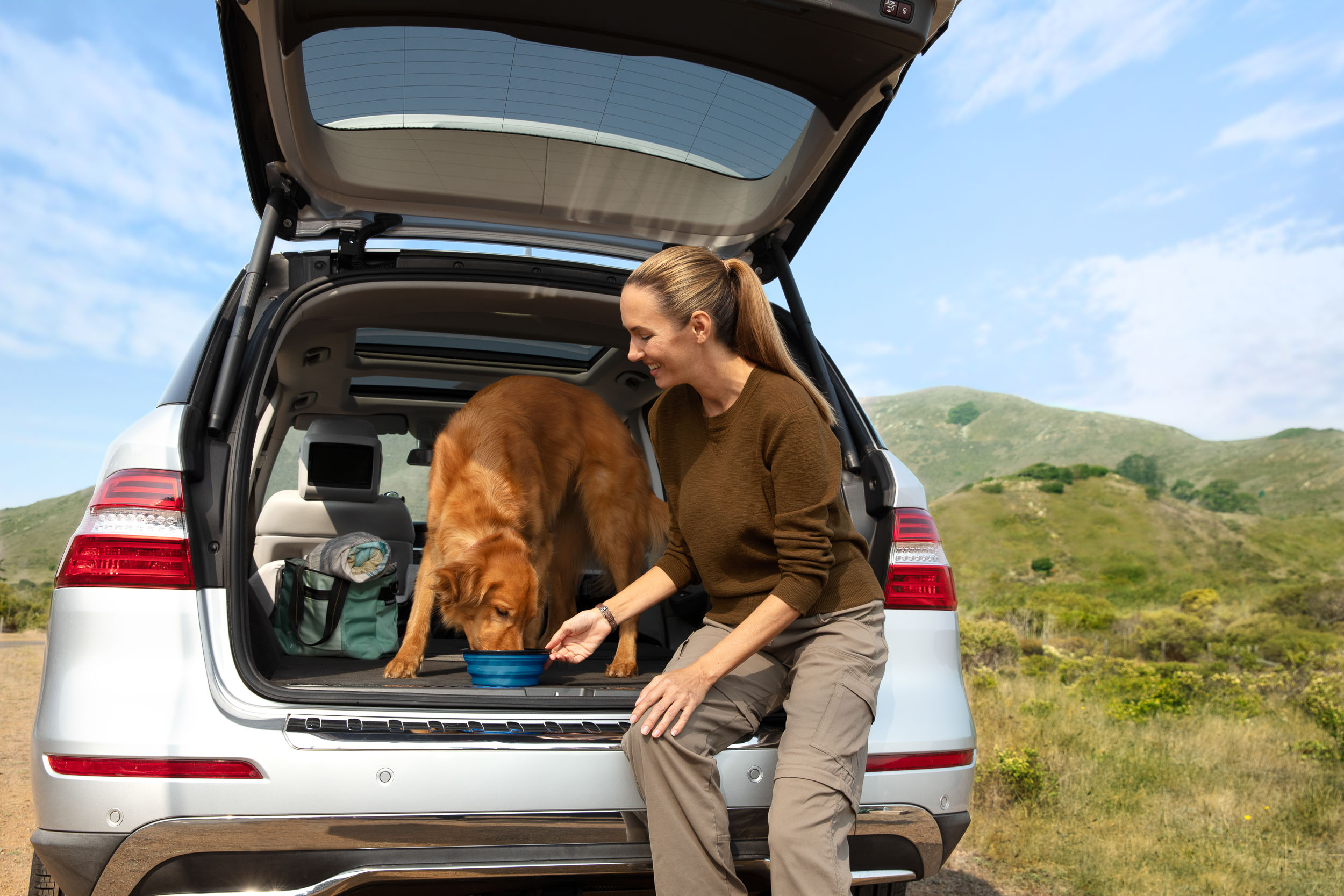Dog and People Photography | Woman Feeding Dog in SUV by Mark Rogers