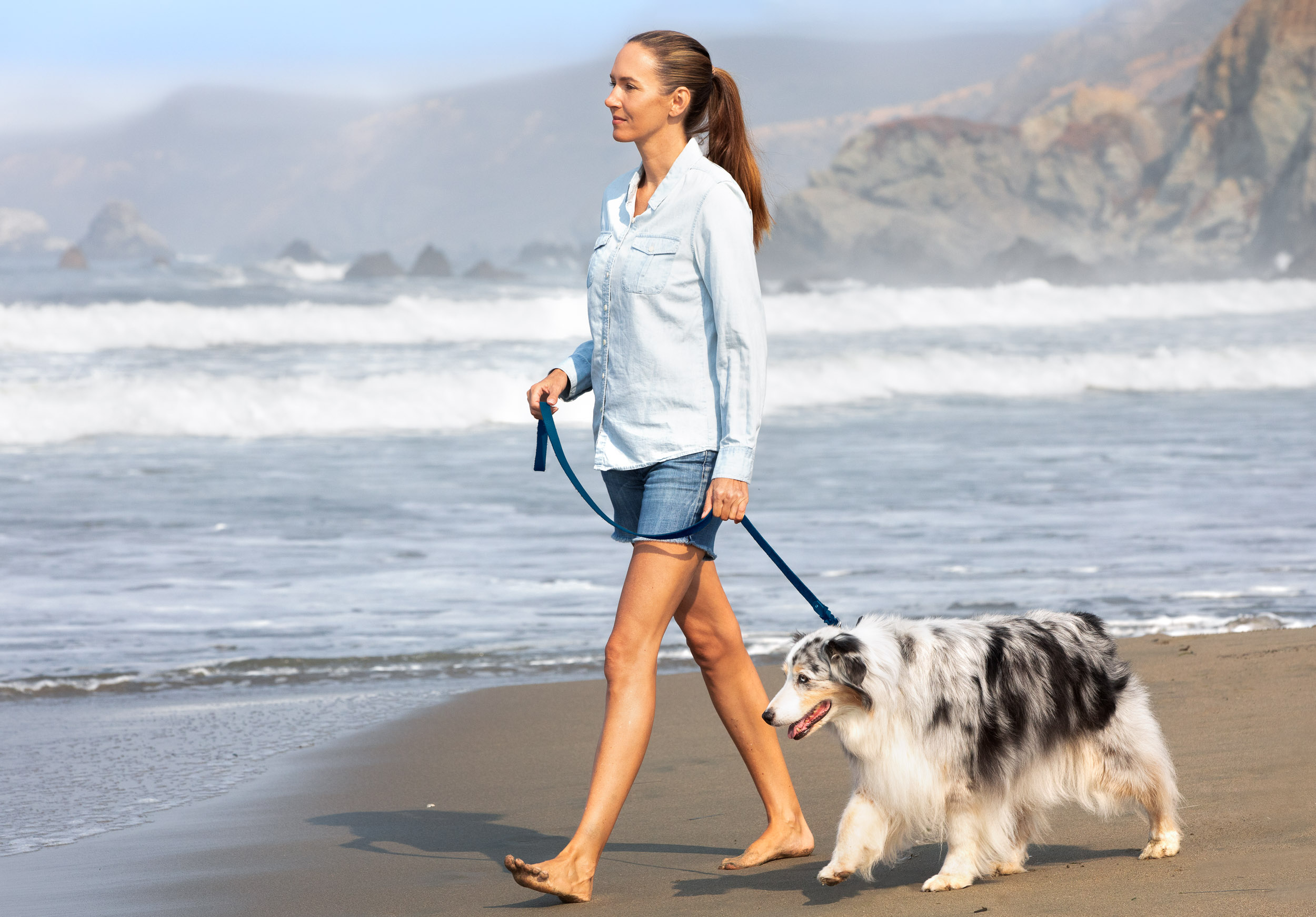 Pet Lifestyle Photography | Woman Walking Dog on Beach