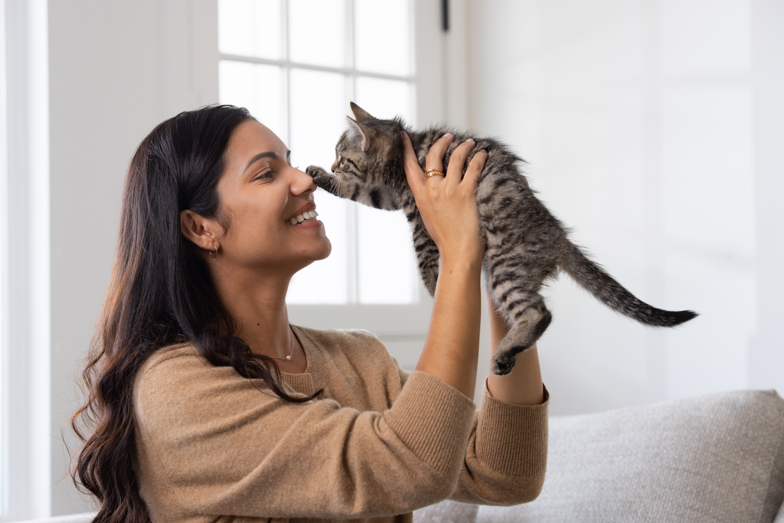 Woman holding kitten face to face