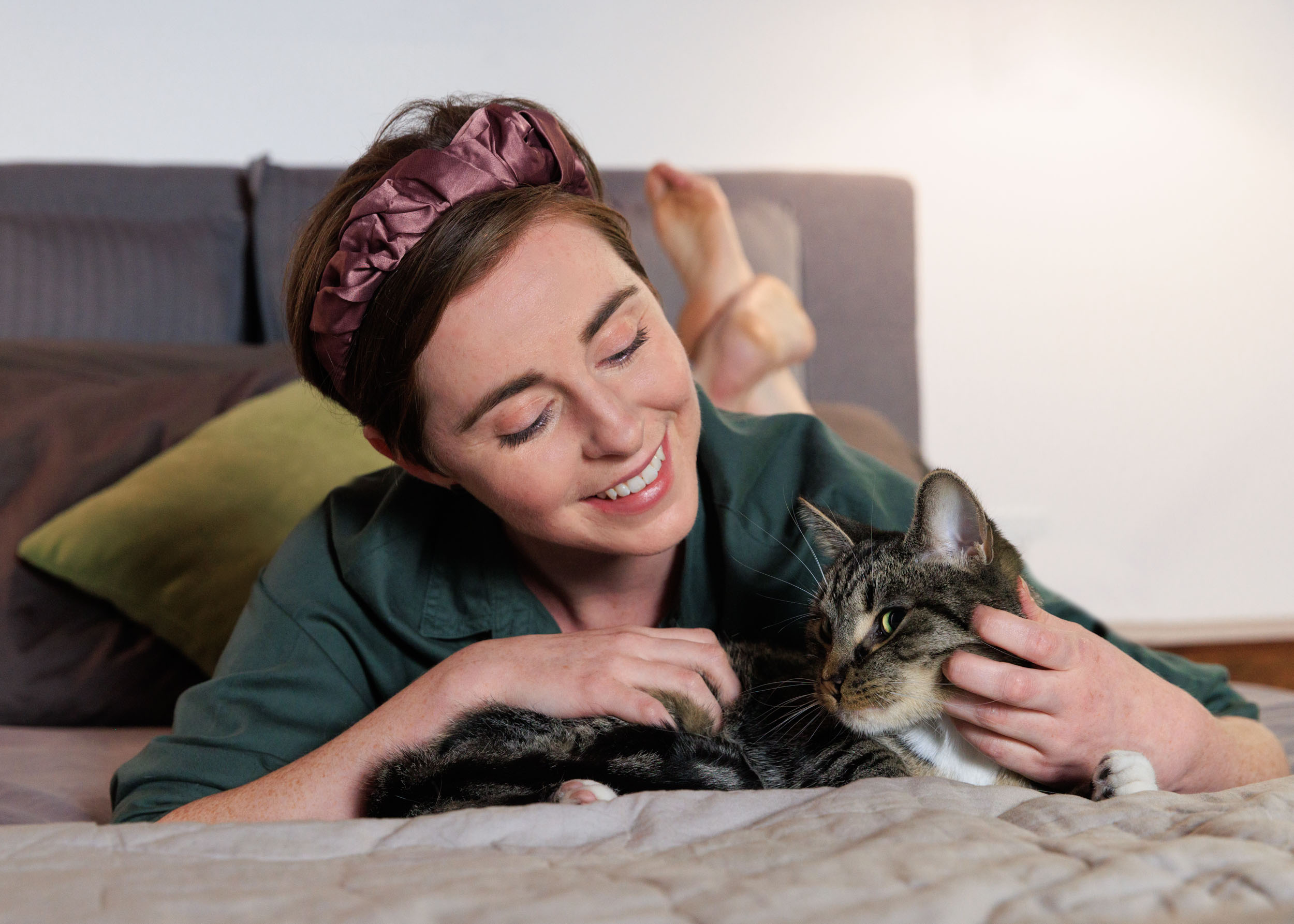 Pet Advertising Photography | Woman Petting Cat on Bed by Mark Rogers